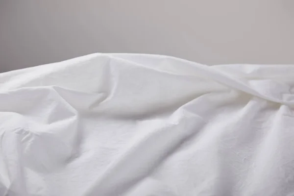 Zerknittertes weißes Tuch isoliert auf grau mit Kopierraum — Stockfoto