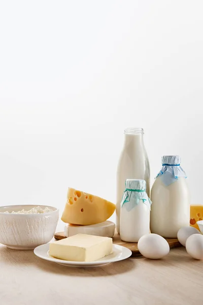 Varios productos lácteos orgánicos frescos y huevos en la mesa de madera aislados en blanco - foto de stock