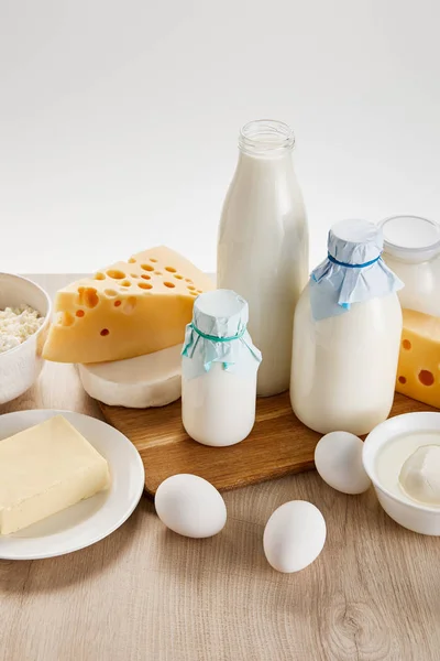 Varios productos lácteos orgánicos frescos y huevos en la mesa de madera aislados en blanco - foto de stock