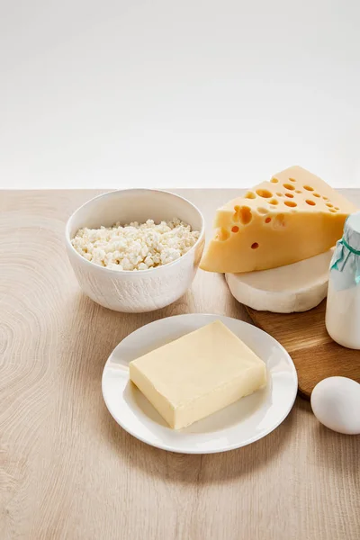 Различные свежие органические молочные продукты и яйцо на деревянном столе изолированы на белом — стоковое фото