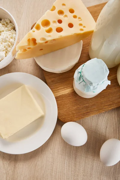 Vista superior de varios productos lácteos orgánicos frescos y huevos en la mesa de madera - foto de stock