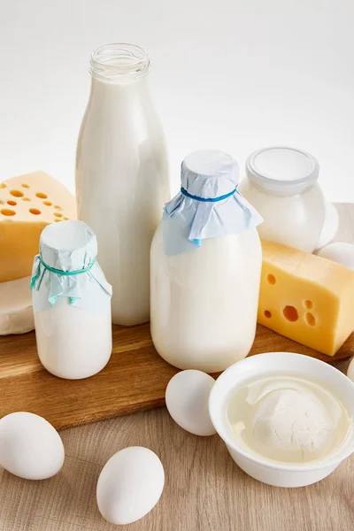 Various fresh organic dairy products and eggs on wooden table isolated on white — Stock Photo