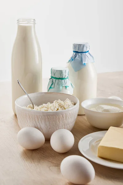Productos lácteos orgánicos frescos y huevos sobre una mesa de madera aislada sobre blanco - foto de stock