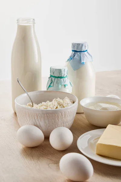 Fresh organic dairy products and eggs on wooden table isolated on white — Stock Photo