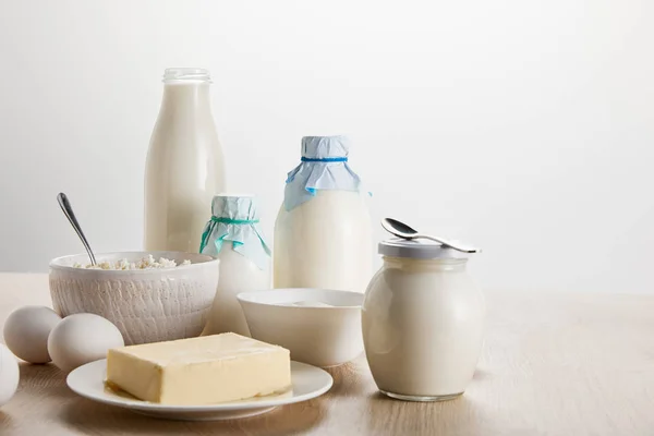 Fresh organic dairy products and eggs on wooden table isolated on white — Stock Photo