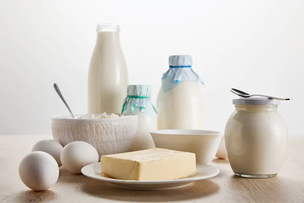 Productos lácteos orgánicos frescos y huevos sobre una mesa de madera aislada sobre blanco - foto de stock