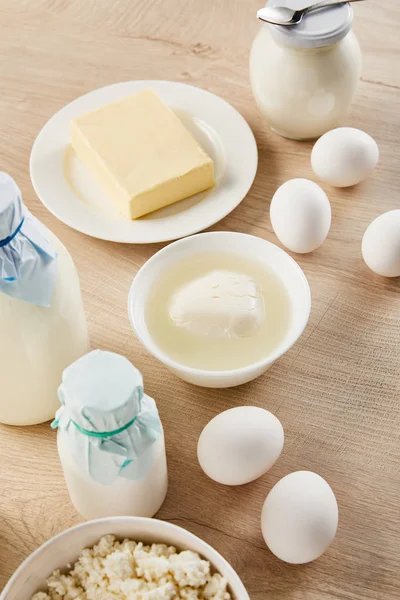 Deliciosos produtos lácteos orgânicos e ovos na mesa de madeira — Fotografia de Stock