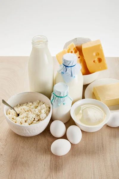 Вкусные органические молочные продукты и яйца на деревянном столе, изолированные на белом — стоковое фото