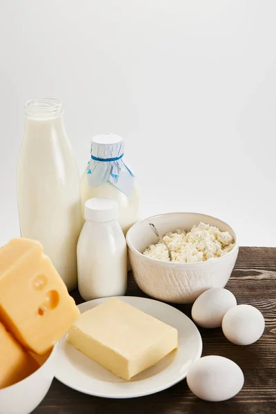 Deliciosos produtos lácteos frescos e ovos em mesa de madeira isolada em branco — Fotografia de Stock