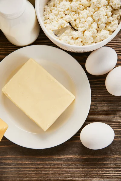 Top view of delicious fresh dairy products and eggs on wooden table — Stock Photo
