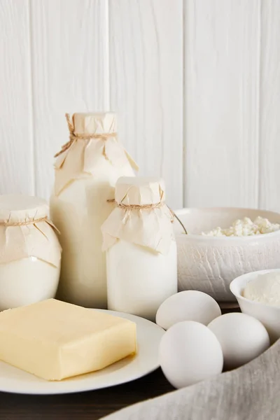 Delicious fresh dairy products and eggs on white wooden background — Stock Photo