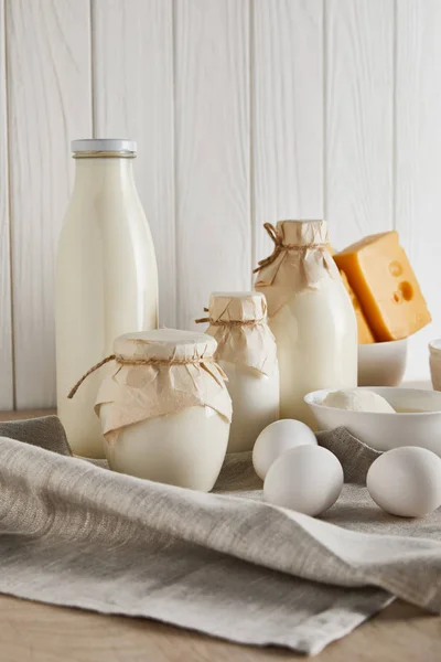 Deliciosos productos lácteos frescos y huevos sobre fondo de madera blanca - foto de stock