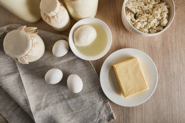 Vista dall'alto di deliziosi latticini freschi e uova su sfondo di legno — Foto stock