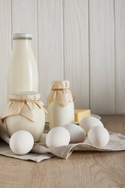 Deliciosos produtos lácteos frescos e ovos em fundo de madeira branca — Fotografia de Stock