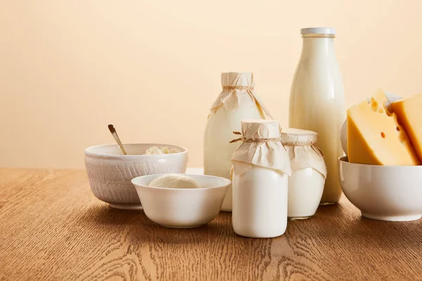 Tasty organic dairy products on rustic wooden table isolated on beige — Stock Photo