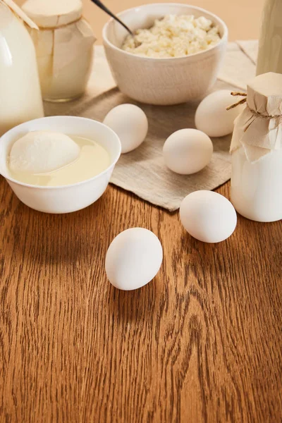 Selective focus of various fresh organic dairy products and eggs on rustic wooden table — Stock Photo