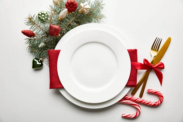 Vue de dessus du cadre de table de Noël festive sur fond blanc avec décoration, branche de pin et bonbons — Photo de stock