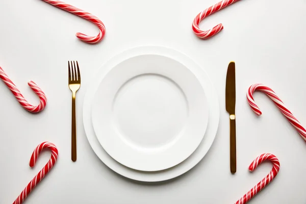 Vue de dessus du cadre de table de Noël festive sur fond blanc avec des bonbons — Photo de stock