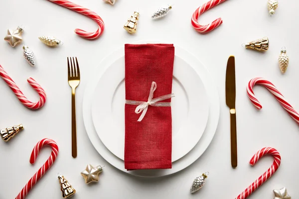 Vue du dessus du décor de table de Noël sur fond blanc avec décoration festive et bonbons — Photo de stock