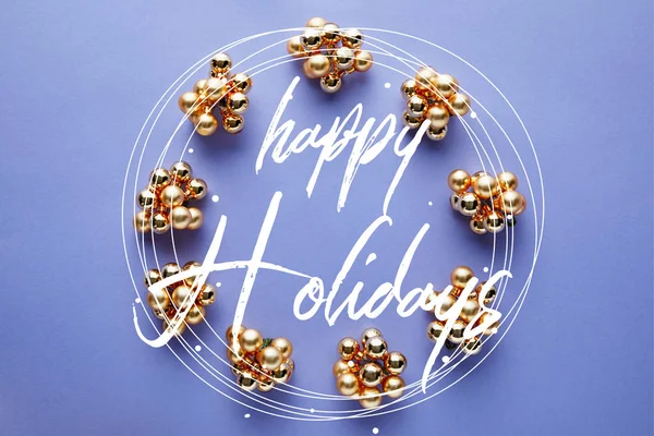 Marco redondo de brillante decoración de Navidad dorada sobre fondo azul con letras Felices fiestas - foto de stock