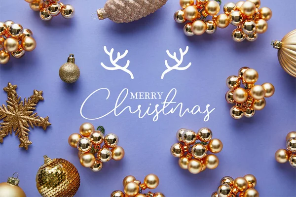 Vista superior de la decoración brillante de Navidad dorada sobre fondo azul con ilustración de Feliz Navidad - foto de stock