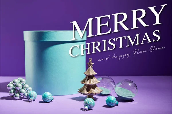 Caixa de presente azul e árvore de Natal decorativa com bugigangas em fundo roxo com Feliz Natal e feliz ilustração do ano novo — Fotografia de Stock