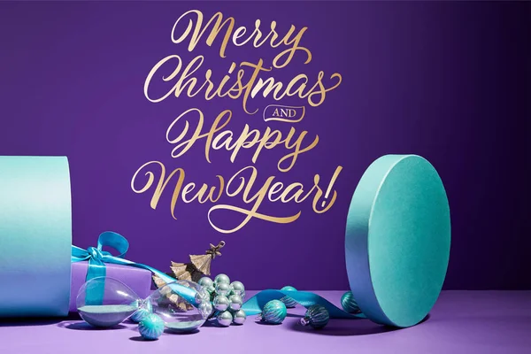 Christmas decoration and hourglass scattered from blue gift box on purple background with Merry Christmas and happy new year illustration — Stock Photo