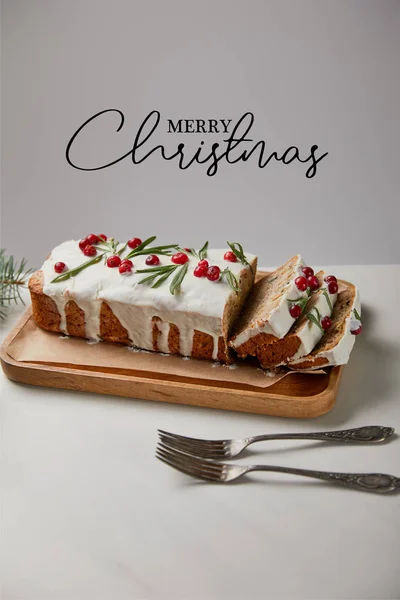 Traditional Christmas cake with cranberry near forks on white table isolated on grey with Merry Christmas illustration — Stock Photo