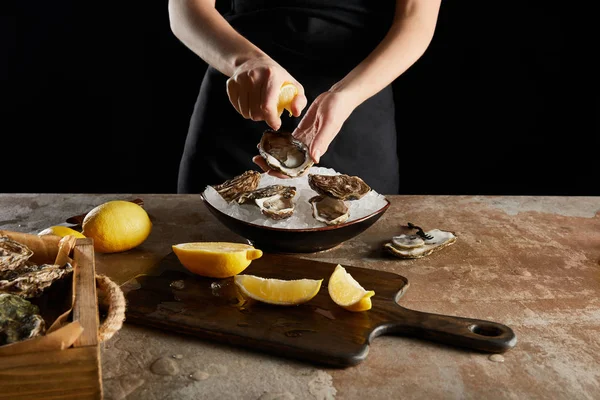 Vista ritagliata di donna spremitura limone su ostrica isolato su nero — Foto stock