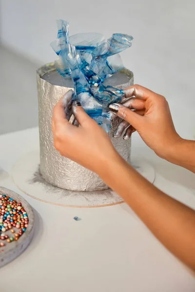 Partial view of confectioner decorating cake in kitchen — Stock Photo