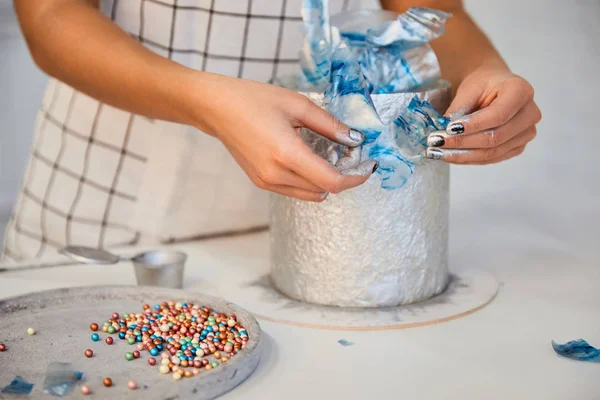 Cropped view of confectioner decorating cake on board — Stock Photo