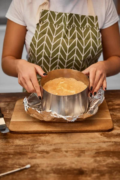 Cropped view of confectioner doing form of cake on chopping board — Stock Photo