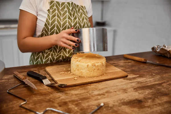 Partial view of confectioner putting cake mold on cake in kitchen — Stock Photo