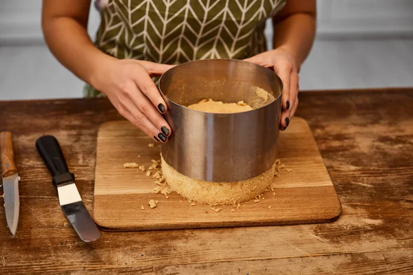 Ausgeschnittene Ansicht eines Konditors, der Kuchen aus Kuchenform nimmt — Stockfoto