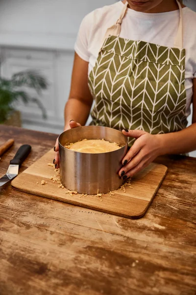 Cropped view of confectioner doing form of cake in kitchen — Stock Photo