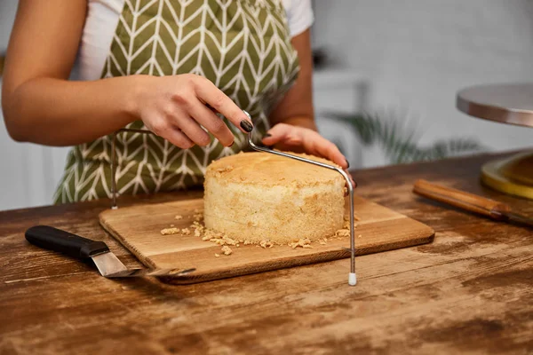 Vista parziale della torta di taglio del pasticciere con affettatrice di torta — Foto stock