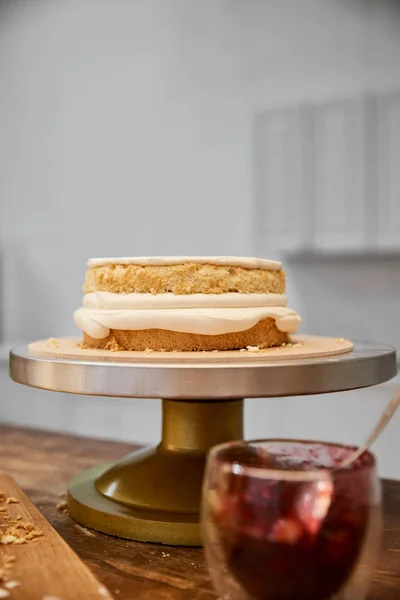 El foco selectivo de la galleta sabrosa con la crema y la confitura en el cristal sobre la mesa - foto de stock