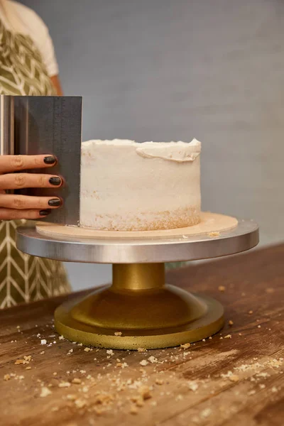 Ausgeschnittener Blick auf Konditor, der süße Sahne auf Keks am Stand ausrichtet — Stockfoto