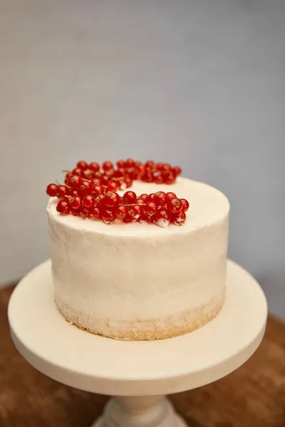 Gâteau éponge savoureux avec crème et groseille fraîche sur le stand de gâteau — Photo de stock