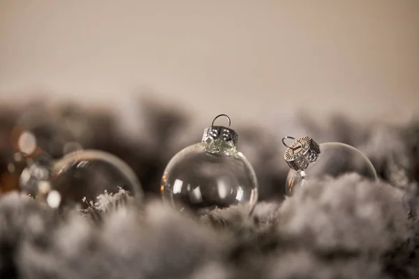 Palline di Natale trasparenti su rami di abete rosso nella neve — Foto stock