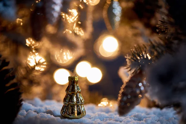 Gros plan de l'arbre de Noël avec des boules de Noël décoratives sur la neige avec des lumières bokeh la nuit — Photo de stock