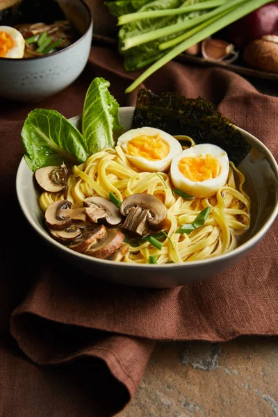 Ramen picante tradicional em arco no guardanapo marrom na superfície de pedra — Fotografia de Stock