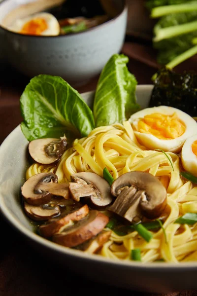 Vista de perto do ramen picante tradicional em tigela no guardanapo marrom na superfície de pedra — Fotografia de Stock