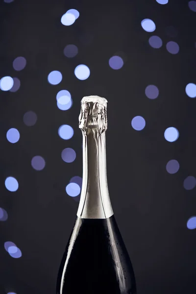 Nahaufnahme einer Sektflasche mit blauem Weihnachtslicht Bokeh — Stockfoto