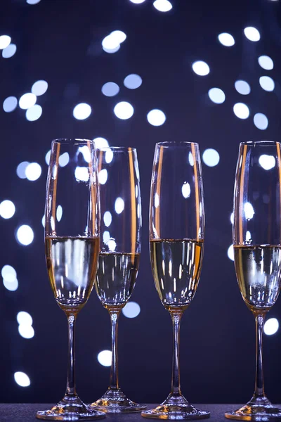 Champagne in bicchieri con luci di Natale blu bokeh — Foto stock