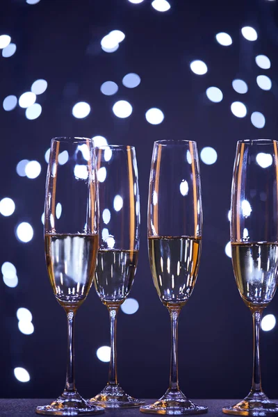Champagne in glasses with blue christmas lights bokeh — Stock Photo