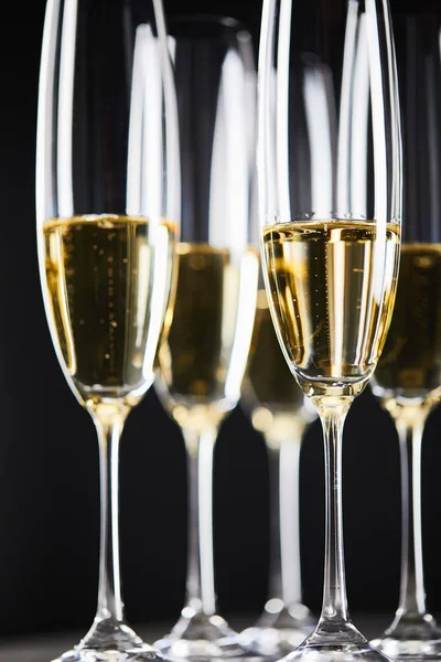 Close up of sparkling wine in glasses on black — Stock Photo