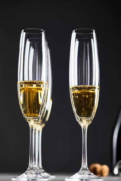Gros plan de champagne dans des verres pour célébrer la veille de Noël sur noir — Photo de stock