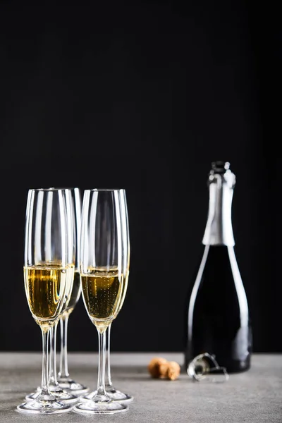 Glasses and bottle of sparkling wine on black — Stock Photo