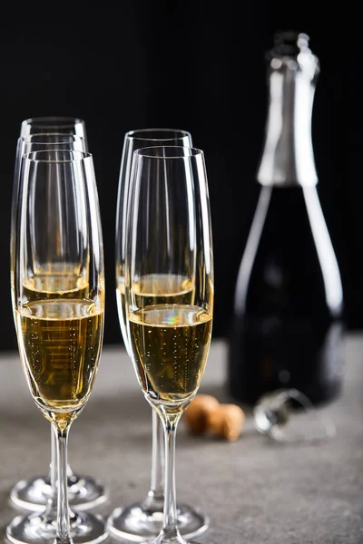 Verres et bouteille de vin mousseux pour célébrer Noël sur noir — Photo de stock